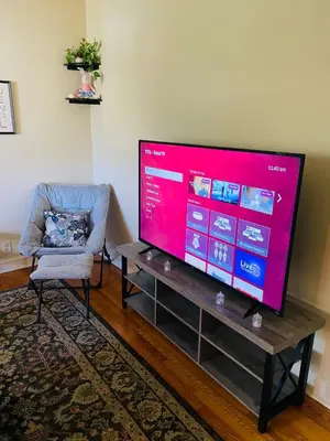 a living room with a large television and a chair at 1BR Near Philly Free Parking, Monthly Discount in Philadelphia