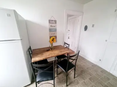 a dining room with a table and chairs and a refrigerator at Cozy & Inviting A Place to Call Home in Melrose Park