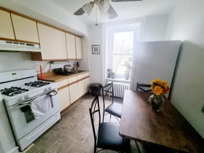 a kitchen with a table and a stove and a refrigerator at Cozy & Inviting A Place to Call Home in Melrose Park