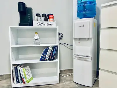 a white refrigerator next to a book shelf with books at Bright, Stylish and Comfy Luxury Room With Workspace! in Haledon