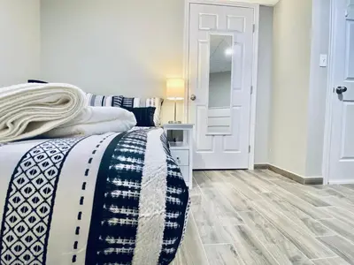 a bedroom with a bed with a black and white blanket at Bright, Stylish and Comfy Luxury Room With Workspace! in Haledon