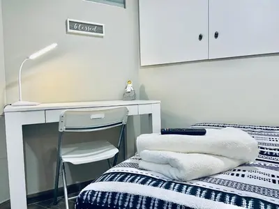 a bedroom with a bed and a desk and a chair at Bright, Stylish and Comfy Luxury Room With Workspace! in Haledon