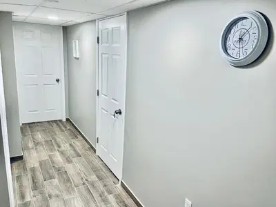 a clock on the wall of a hallway at Bright, Stylish and Comfortable Room with Workspace! in Haledon