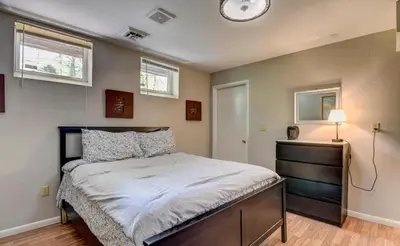 a bedroom with a bed and a clock on the wall at Hot tub, Sauna, fire pit, games and nature in Lake Poconos in Pocono Summit