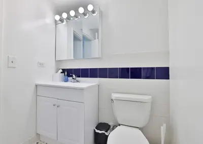 a white bathroom with a toilet and a sink at Hudson River waterfront apt w sweeping NYC views in Hoboken