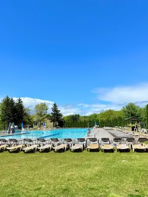 a group of lounge chairs in front of a swimming pool at Modern Home - Privacy - Prime Location - 18min Camelback Ski Resort in Tobyhanna