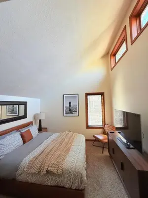 a bedroom with a bed and a desk and windows at Modern Home - Privacy - Prime Location - 18min Camelback Ski Resort in Tobyhanna
