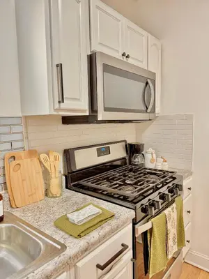 a kitchen with a stove and a microwave at Spacious 3BR Apartment - 12min Newark Airport -Near NYC & Malls in Newark