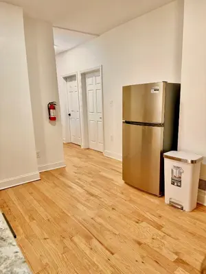 an empty room with a stainless steel refrigerator at Spacious 3BR Apartment - 12min Newark Airport -Near NYC & Malls in Newark