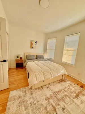 a bedroom with a large bed and a rug at Spacious 3BR Apartment - 12min Newark Airport -Near NYC & Malls in Newark