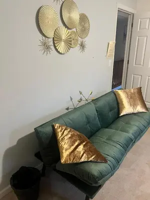 a green couch with gold pillows in a living room at Golden Deer Lodge in Tobyhanna