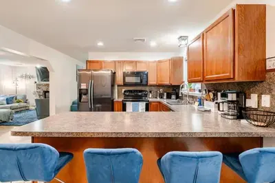 a kitchen with a large counter with blue chairs at Golden Deer Lodge in Tobyhanna
