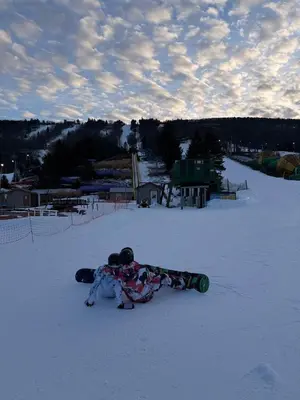 a person laying in the snow with a snowboard at Golden Deer Lodge in Tobyhanna