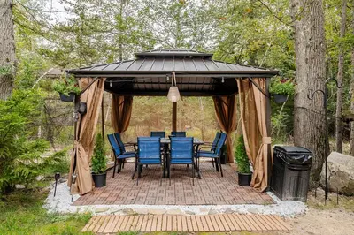 a gazebo with a table and chairs under it at Golden Deer Lodge in Tobyhanna