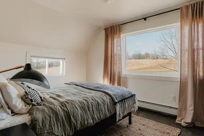 a bedroom with a bed and a large window at Luxe Gabel Farmhouse Fire Pit & Country Views in Callicoon