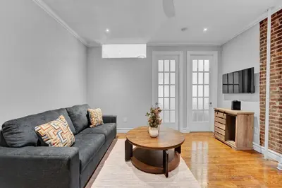 a living room with a couch and a table at Modern 2BR with Private Garden - In Gramercy Park in New York