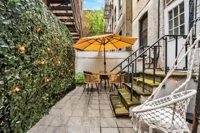 a patio with a table and an umbrella at Modern 2BR with Private Garden - In Gramercy Park in New York