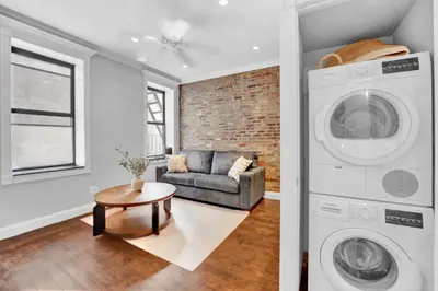 a living room with a washing machine and a couch at Gramercy Apartment - 3BR 2BA Modern Central in New York