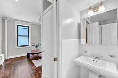 a white bathroom with a sink and a mirror at Gramercy Apartment - 3BR 2BA Modern Central in New York