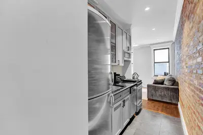 a kitchen with a stainless steel refrigerator and a stove at Gramercy Apartment - 3BR 2BA Modern Central in New York