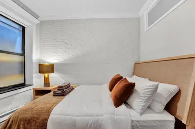 a bedroom with a large white bed with a window at Gramercy Apartment - 3BR 2BA Modern Central in New York