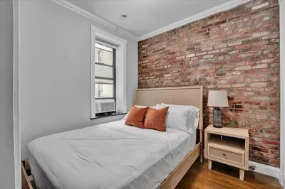 a bedroom with a brick wall and a bed at Gramercy Apartment - 3BR 2BA Modern Central in New York