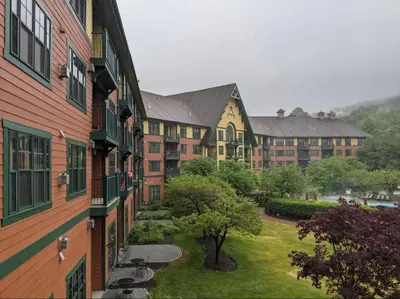 a row of apartment buildings with a yard and trees at Cozy Studio Resort Stay Mountain Creek Pool Hiking in Vernon Township