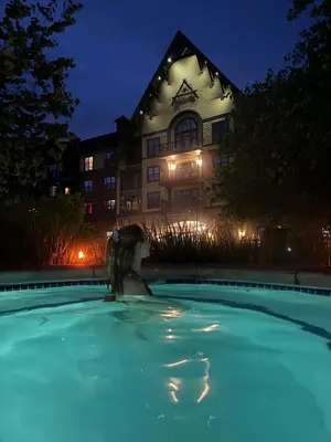 a woman sitting in a swimming pool in front of a building at Cozy Studio Resort Stay Mountain Creek Pool Hiking in Vernon Township