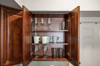 a wooden cabinet with glasses and cups in it at New Modern Apt in Chinatown Parking Available in Philadelphia