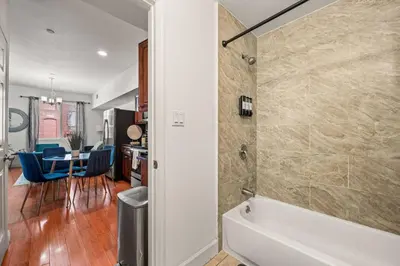 a bathroom with a tub and a kitchen with a table at New Modern Apt in Chinatown Parking Available in Philadelphia
