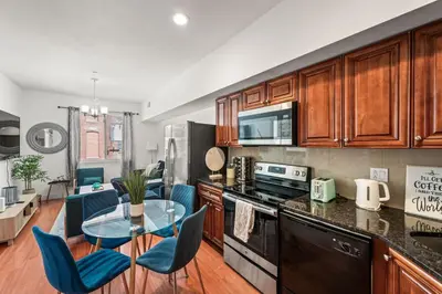 a kitchen with a glass table and blue chairs at New Modern Apt in Chinatown Parking Available in Philadelphia