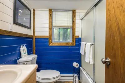 a blue bathroom with a toilet and a sink at Lake Harmony Getaway in Lake Harmony