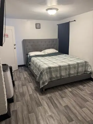 a bedroom with a bed and a wooden floor at Private Basement near NYC and NJ attractions in East Orange