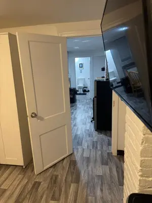 an open door to a living room with wooden floors at Private Basement near NYC and NJ attractions in East Orange