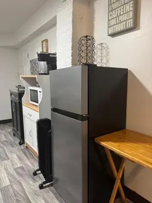 a kitchen with a stainless steel refrigerator and a table at Private Basement near NYC and NJ attractions in East Orange