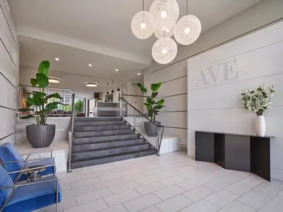 a lobby with a staircase and a chandelier at AVE Clifton - Furnished Apartment, Clifton NJ in Clifton