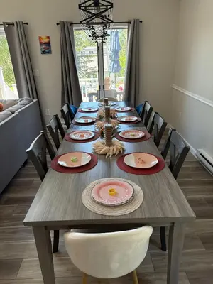 a long wooden table with chairs and plates on it at The Beachside Escape in Tobyhanna