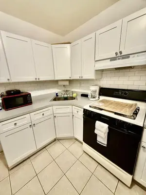 a kitchen with white cabinets and a black stove top oven at NYCRiverside 2BR Apt 20MintsTime Square in West New York
