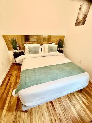 a bedroom with a large white bed with wooden floors at NYCRiverside 2BR Apt 20MintsTime Square in West New York