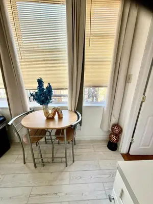 a table and chairs in a kitchen with windows at RiverEdge Apt Gateway20Mints FromTime SquareNYC in West New York