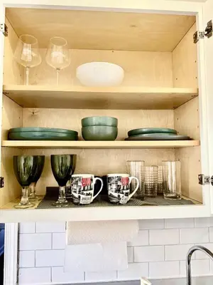 a cupboard with plates and mugs and dishes on it at RiverEdge Apt Gateway20Mints FromTime SquareNYC in West New York