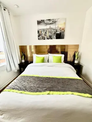 a bedroom with a large bed with green pillows at RiverEdge Apt Gateway20Mints FromTime SquareNYC in West New York