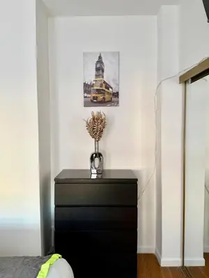 a black dresser with a vase on it in a bedroom at RiverEdge Apt Gateway20Mints FromTime SquareNYC in West New York