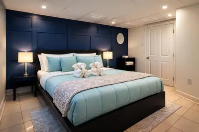 a blue bedroom with a large bed with flowers on it at Nice 3BR Apt | 3 Beds |15 Min to NYC/Manhattan! in North Bergen