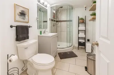 a white bathroom with a toilet and a shower at Nice 3BR Apt | 3 Beds |15 Min to NYC/Manhattan! in North Bergen