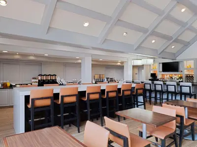 a restaurant with tables and chairs and a bar at Hyatt House Parsippany East in Parsippany
