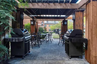 a patio with chairs and a grill and tables at Hyatt House Parsippany East in Parsippany