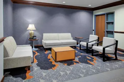a waiting room with a couch and two chairs at Hyatt House Parsippany East in Parsippany