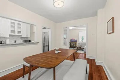 a living room with a wooden table and a kitchen at Chestnut Hill 2BR Easy Parking in Philadelphia