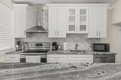a kitchen with white cabinets and a stove top oven at Chestnut Hill 2BR Easy Parking in Philadelphia